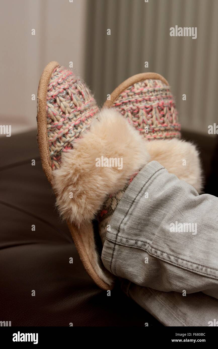 Una donna di relax con i suoi piedi indossando pantofole England Regno Unito Foto Stock