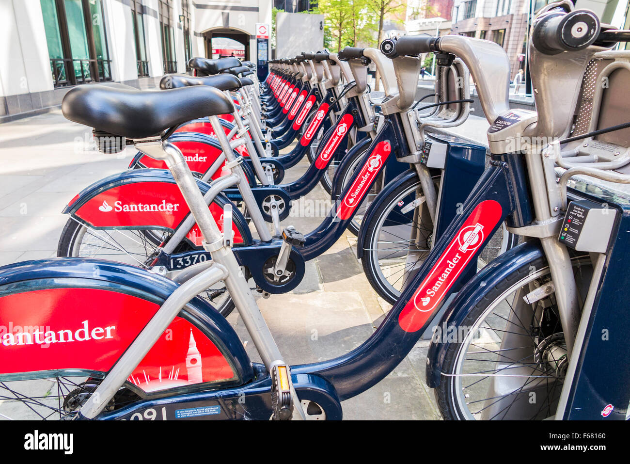 Boris bikes con la Rossa di Santander il logo di sponsorizzazione, parcheggiata in uno stand nella città di Londra - Inghilterra Foto Stock