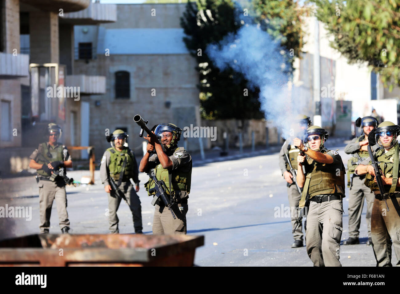 Soldati israeliani fire le scatole metalliche del gas lacrimogeno in dimostranti (non visibile) durante scontri con la gioventù palestinese in Cisgiordania città di Betlemme. Dopo un'altra settimana di violenza nei territori occupati palestinesi, scontri scoppiati in Cisgiordania città di Betlemme tra giovani palestinesi e soldati israeliani. Sono continuati gli scontri nelle ore serali. La recente ondata di violenza che ha eruttato durante la settimana era stato condannato da Amnesty International come pure i Medici Senza Frontiere (MSF) dopo aver coperto le forze israeliane assalto di un ospedale governativo in Cisgiordania città di Hebron, tiro e k Foto Stock