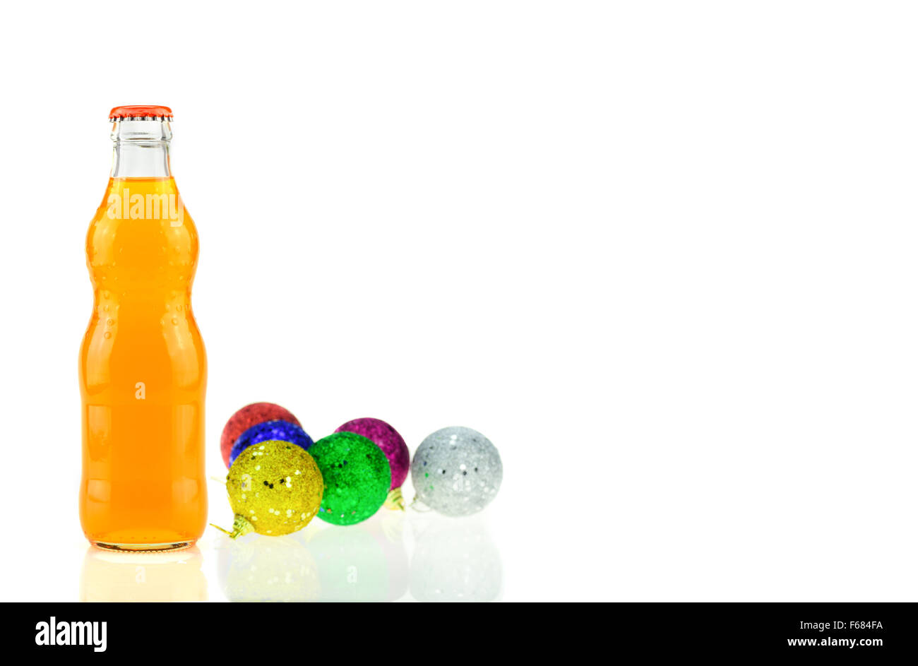 Bottiglia di Fanta Orange (coca cola) vetro soda e decorazione di Natale con pallina sfera su sfondo bianco Foto Stock