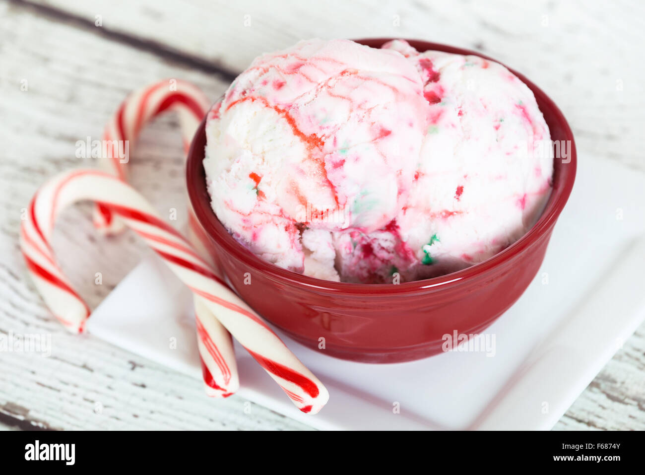 La menta piperita il gelato in una ciotola rossa e candy canes Foto Stock