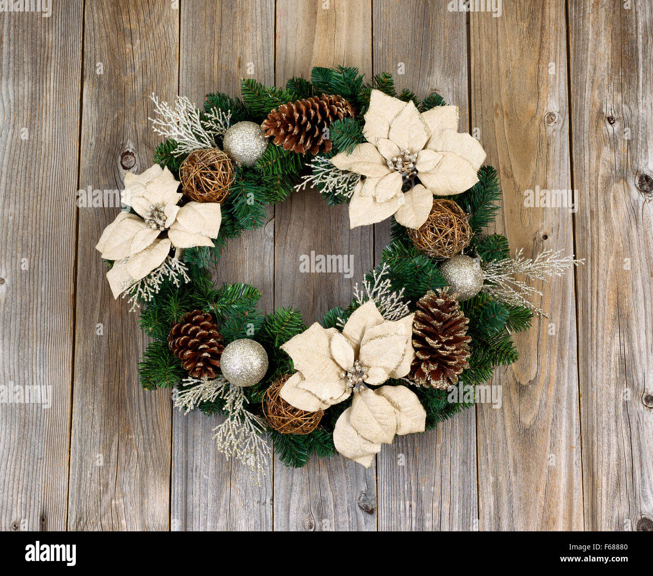 Bianco fiore Poinsettia e cono di pino ghirlanda di Natale su rustiche in legno di cedro. Foto Stock