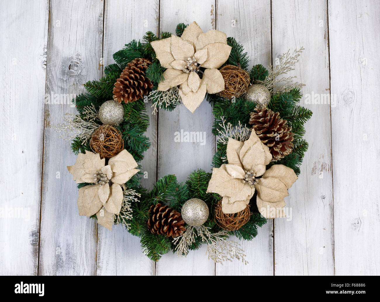 Bianco fiore Poinsettia e cono di pino ghirlanda di Natale su rustiche in legno bianco. Foto Stock