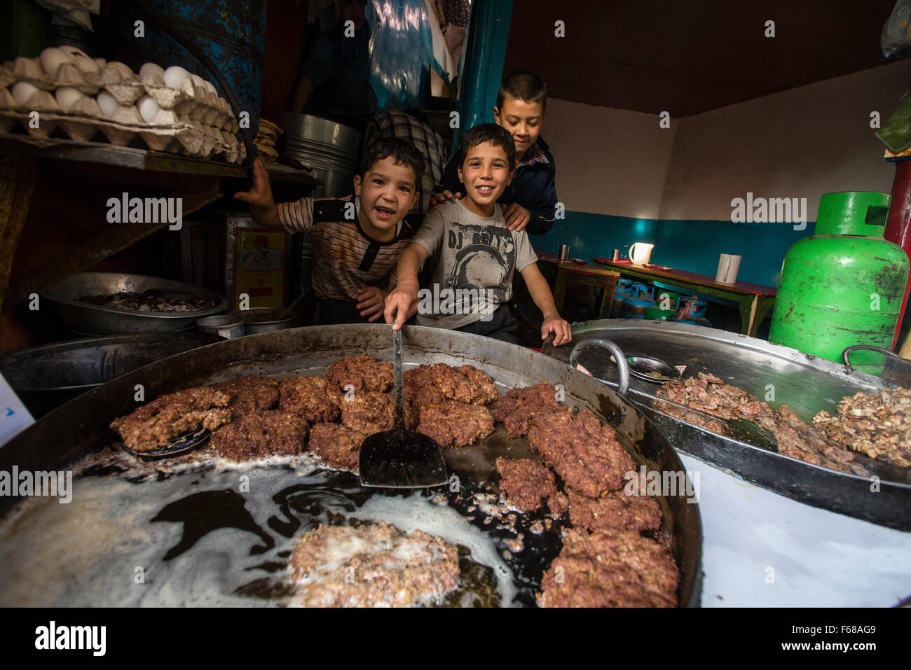 Aiutare i bambini nel ristorante tradizionale a Ka Farushi Bird's mercato, Kabul, Afghanistan Foto Stock