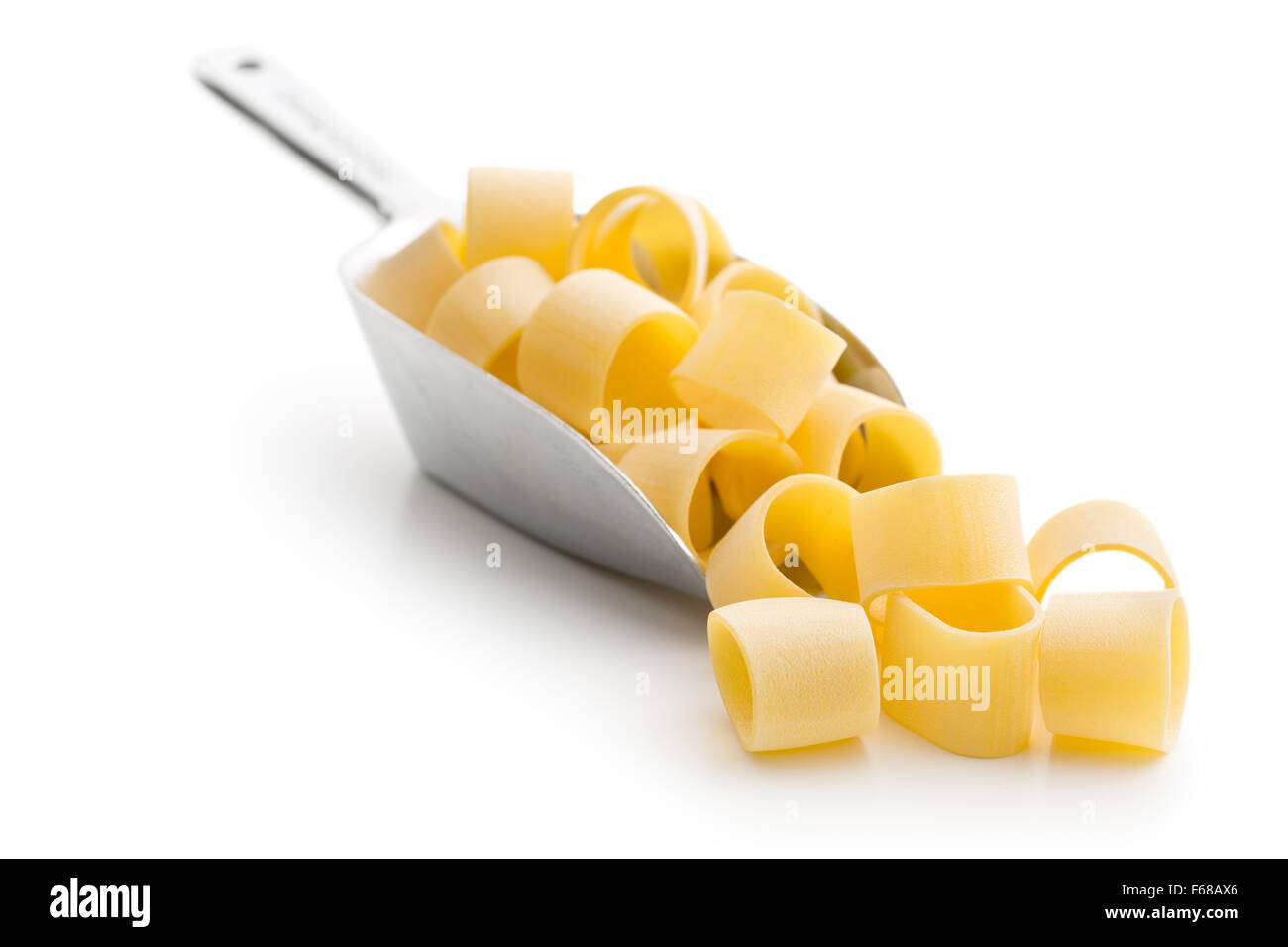 Paste alimentari non cotte calamarata in metallo scoop su sfondo bianco Foto Stock