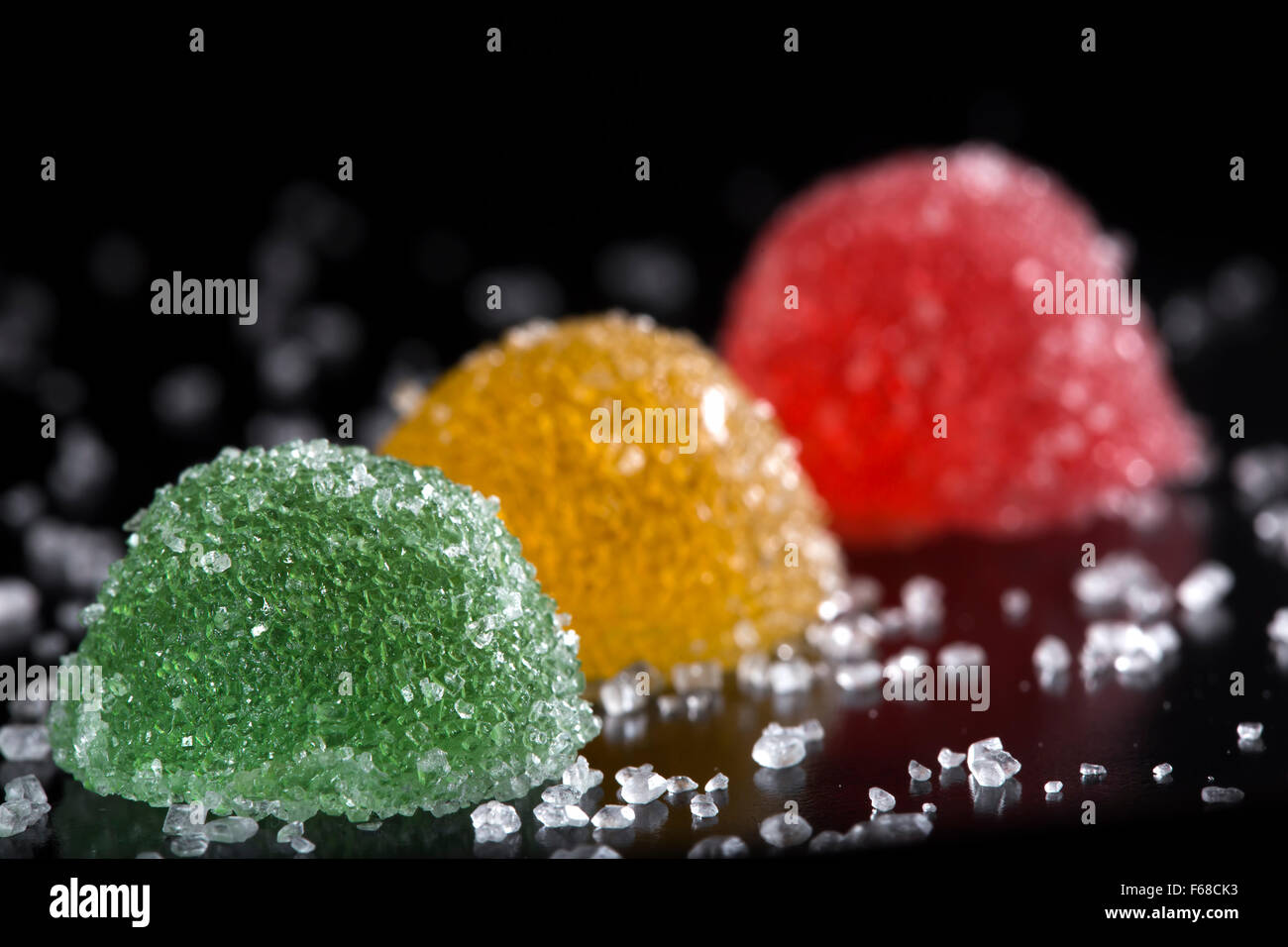 Gelatina colorata di caramelle con zucchero su sfondo scuro Foto Stock