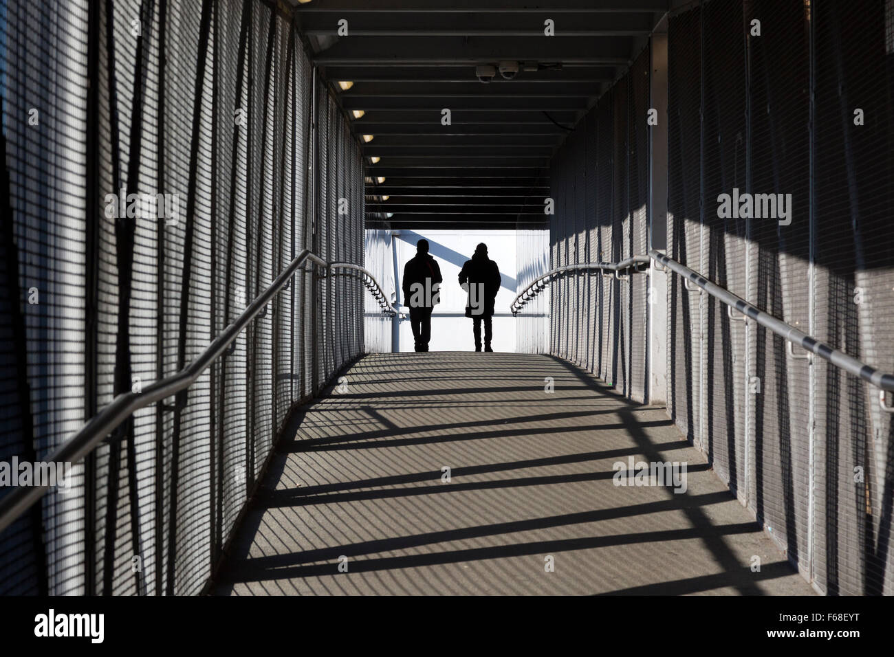 Persone attraversando ponte sulla ferrovia, feltham, middlesex Foto Stock