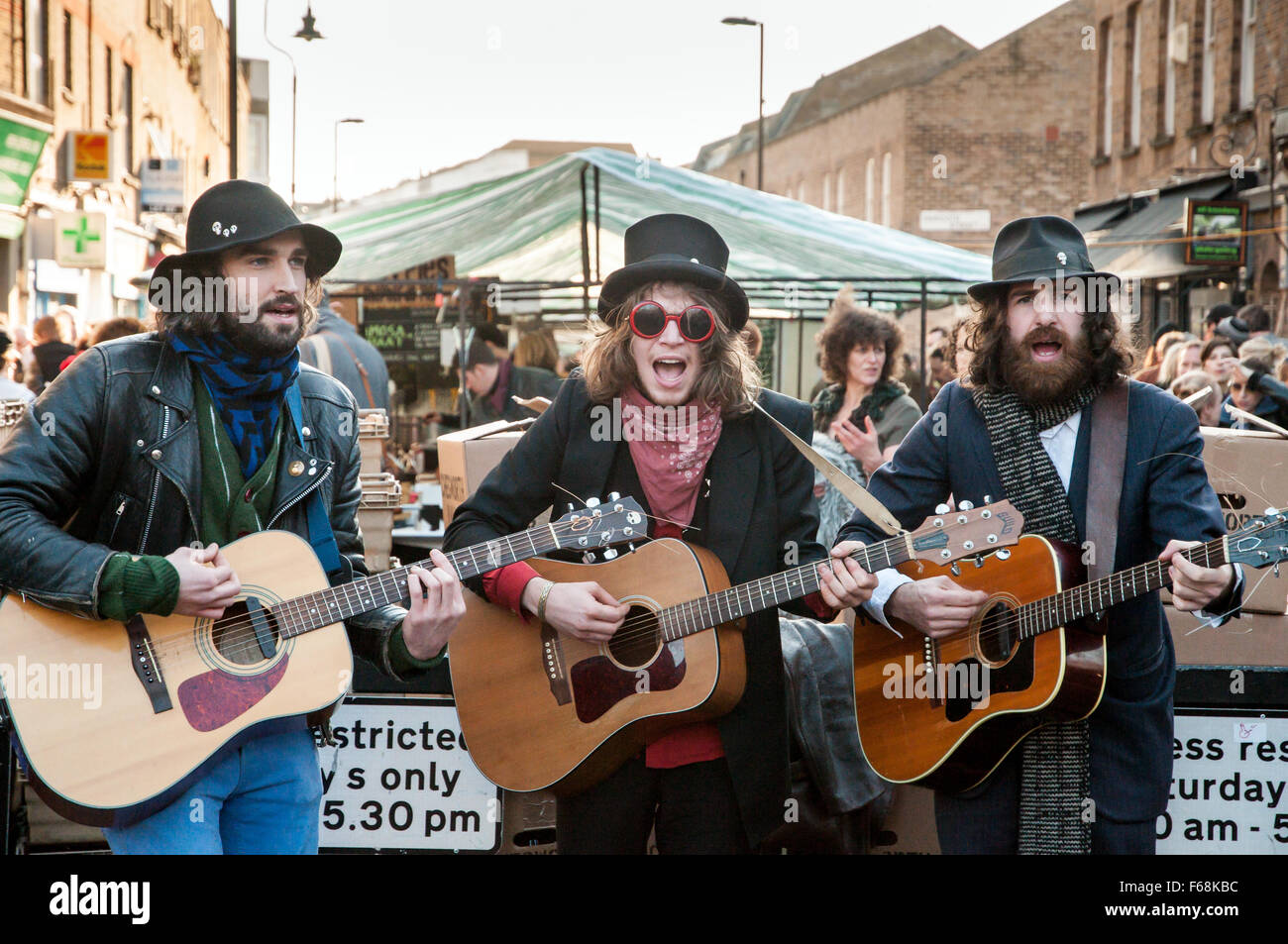 Tre musicisti a suonare la chitarra in Broadway Market, Hackney, Londra, Inghilterra, Regno Unito Foto Stock