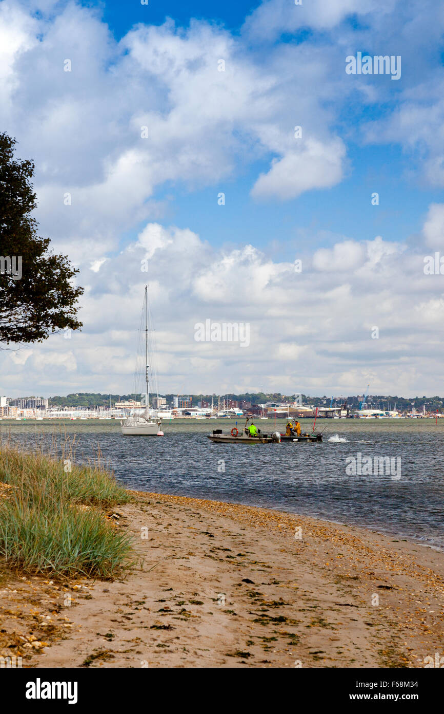 Due barche da pesca sul loro modo home passato la RSPB Arne riserva nel porto di Poole, Dorset, Inghilterra. Foto Stock