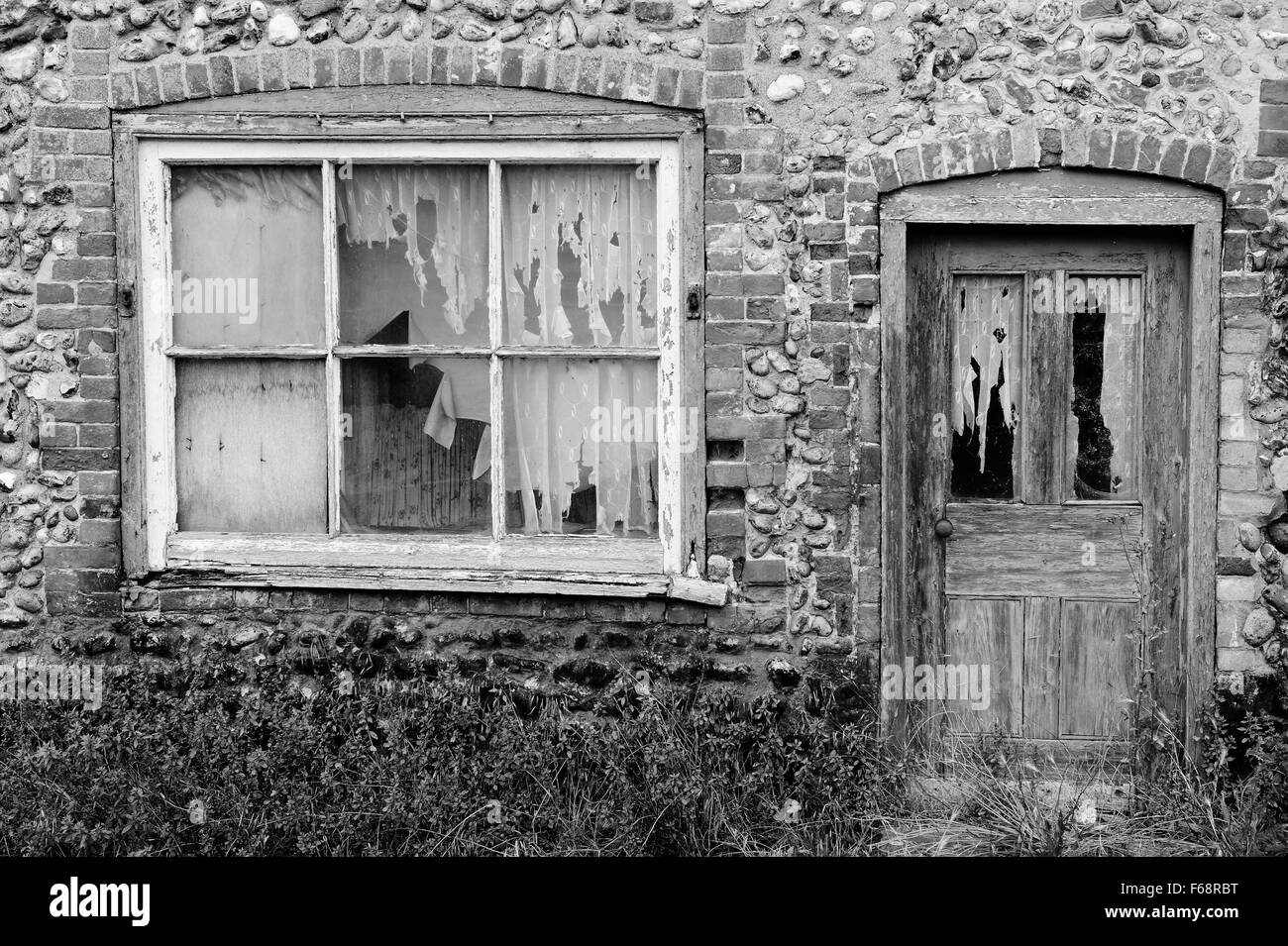 Abbandonata la selce e mattoni rossi cottage, Inghilterra England Regno Unito Foto Stock