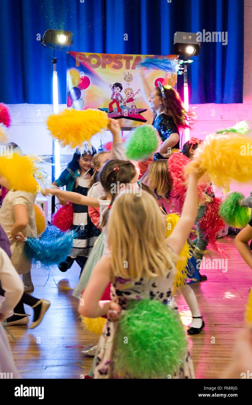 Ritratto verticale di giovani ragazze che ballano con il pom pom ad una festa di compleanno. Foto Stock