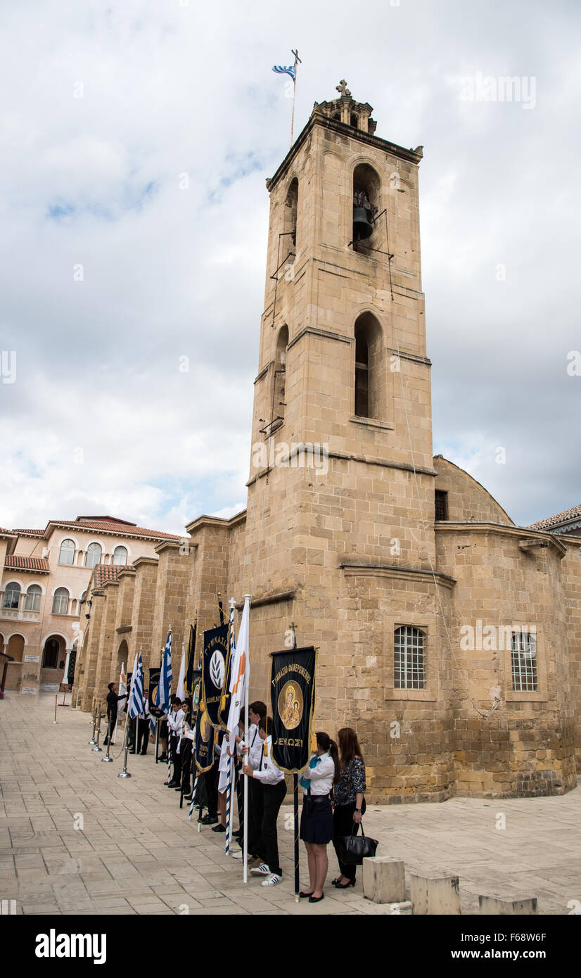 Gli studenti con la loro scuola di bandiere e di simboli in piedi al di fuori della chiesa di Agios Ioannis a Nicosia Foto Stock