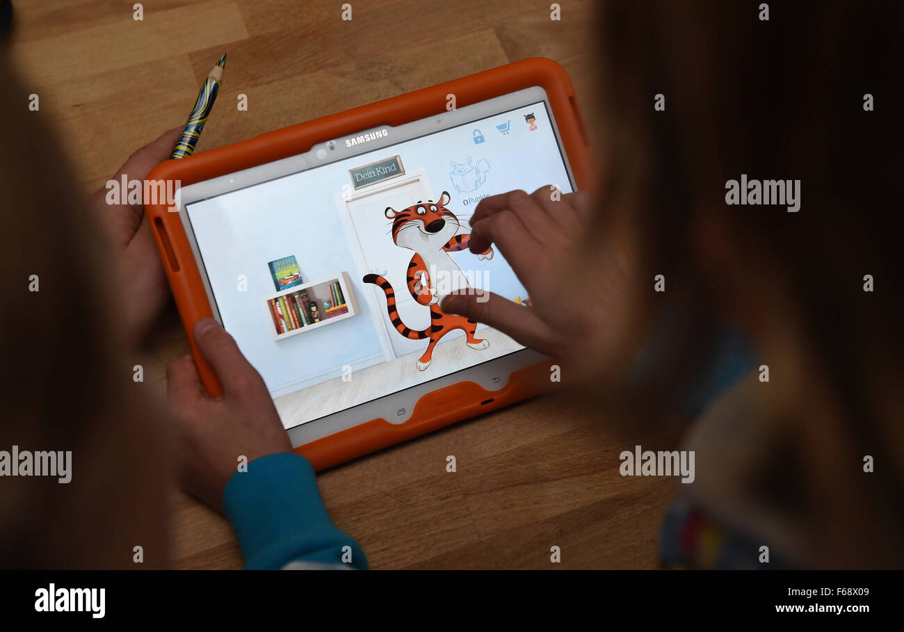 Oldenburg (Germania). Decimo Nov, 2015. Dieci-anno-vecchio Peeke gioca un gioco educativo su un tablet con sua madre in casa loro a Oldenburg, Germania, 10 novembre 2015. La pubblicazione le aziende sono sempre più che offre applicazioni e giochi educativi in aggiunta ai tradizionali libri illustrati. Foto: CARMEN JASPERSEN/dpa/Alamy Live News Foto Stock