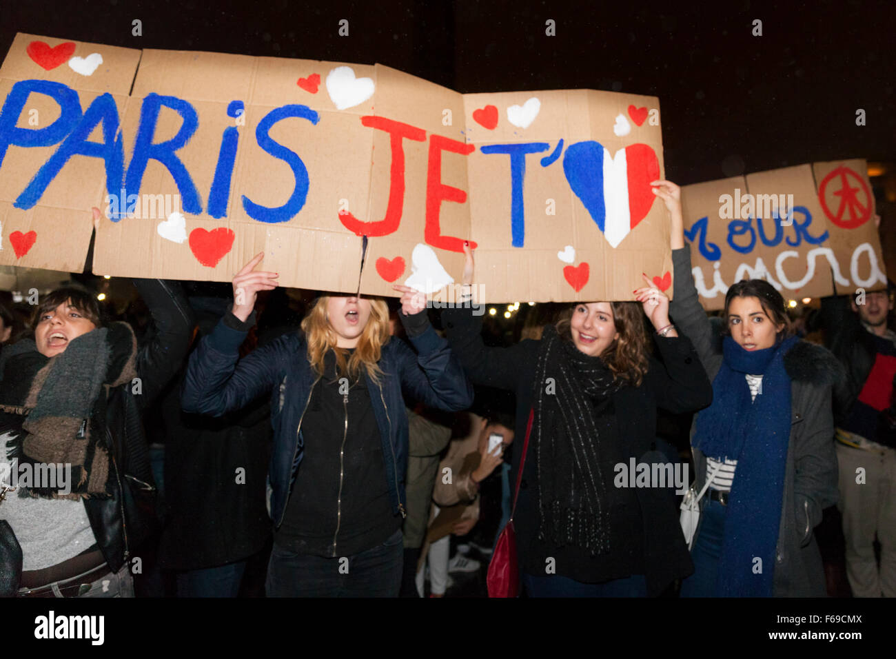 Londra, Regno Unito. Il 14 novembre 2015. Un gruppo di studenti in possesso di un "Paris Je t'aime" segno come migliaia di fedeli in Trafalgar Square a pagare il loro rispetto alle vittime in Francia e dimostrare la loro solidarietà a seguito di attacchi di Parigi Foto Stock
