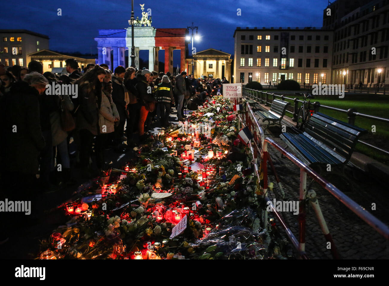 Berlino, Germania. Xiv Nov, 2015. Persone in lutto partecipare a un raduno in memoria di vittime uccise nel venerdì di attacchi come la Porta di Brandeburgo è illuminato nella nazionale francese colori a Parigi vicino ambasciata francese in Germania, Berlino, Germania, il 9 novembre 14, 2015. Credito: Zhang ventola/Xinhua/Alamy Live News Foto Stock