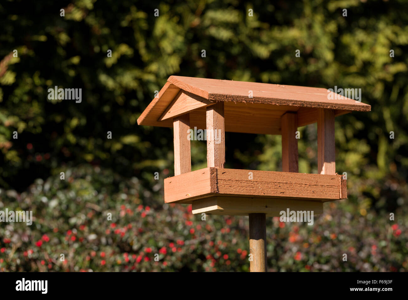 In casa semplice legno Bird Feeder installato su giardino Foto Stock