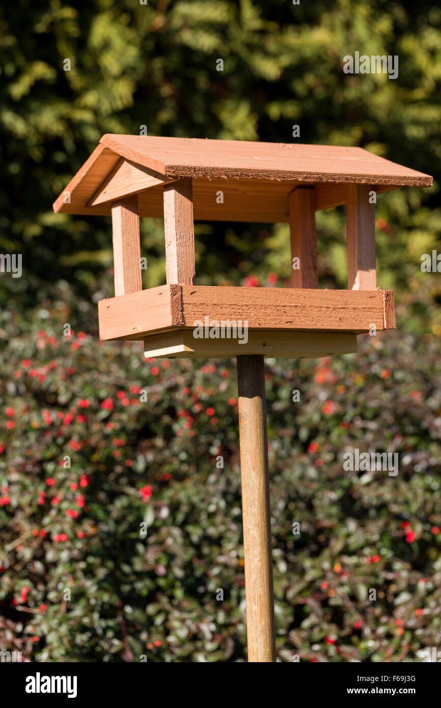 In casa semplice legno Bird Feeder installato su giardino Foto Stock