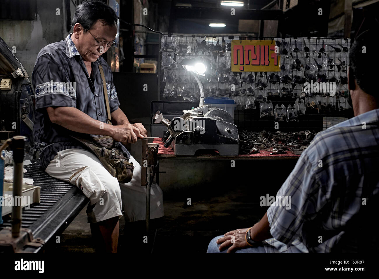Lavoro notturno. La taglierina funziona di notte. Thailandia Street scena Foto Stock