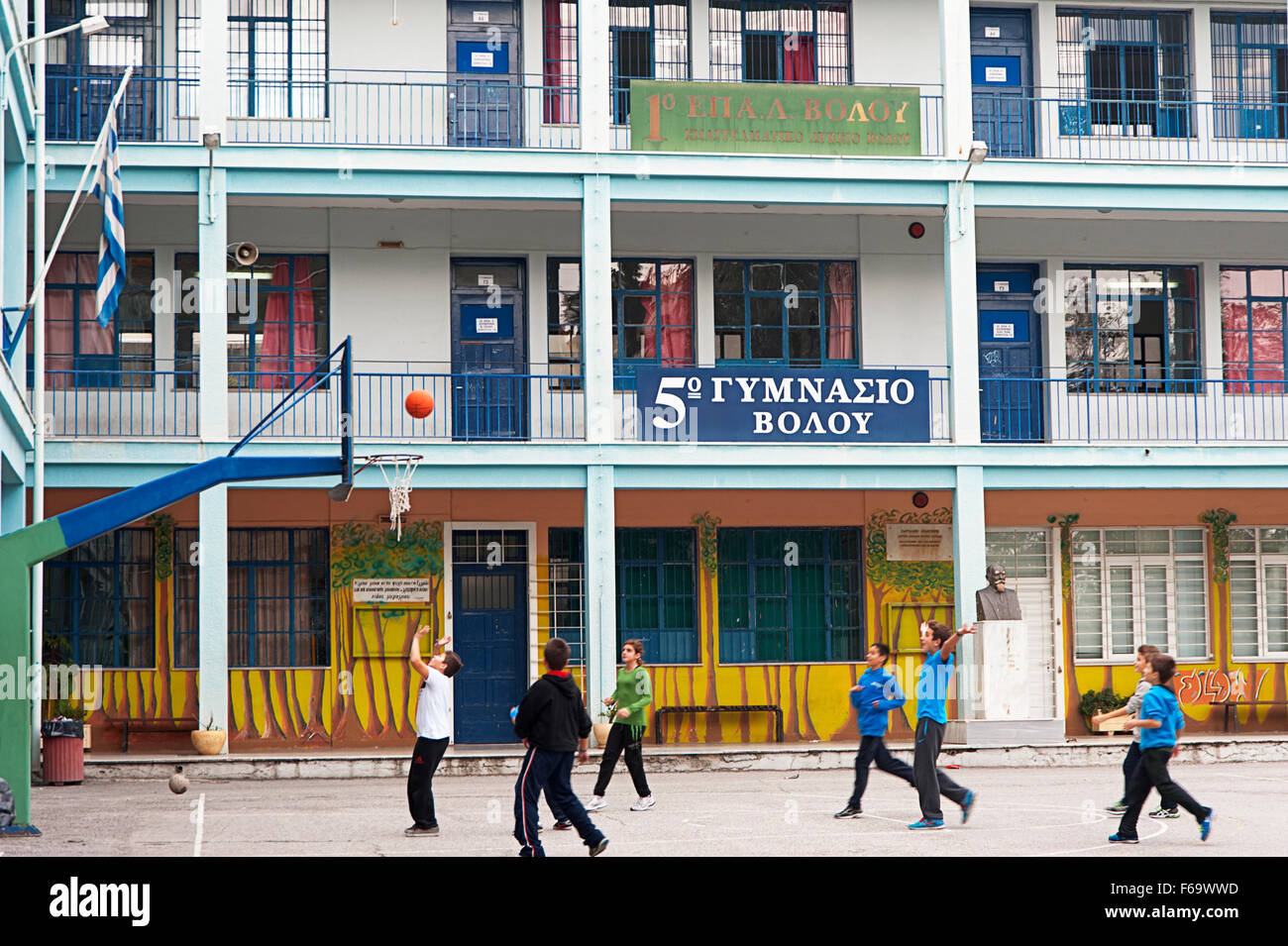 Ragazzi che giocano a basket in schoolyard di una scuola di grammatica nella città di Volos, Tessaglia, Grecia Foto Stock