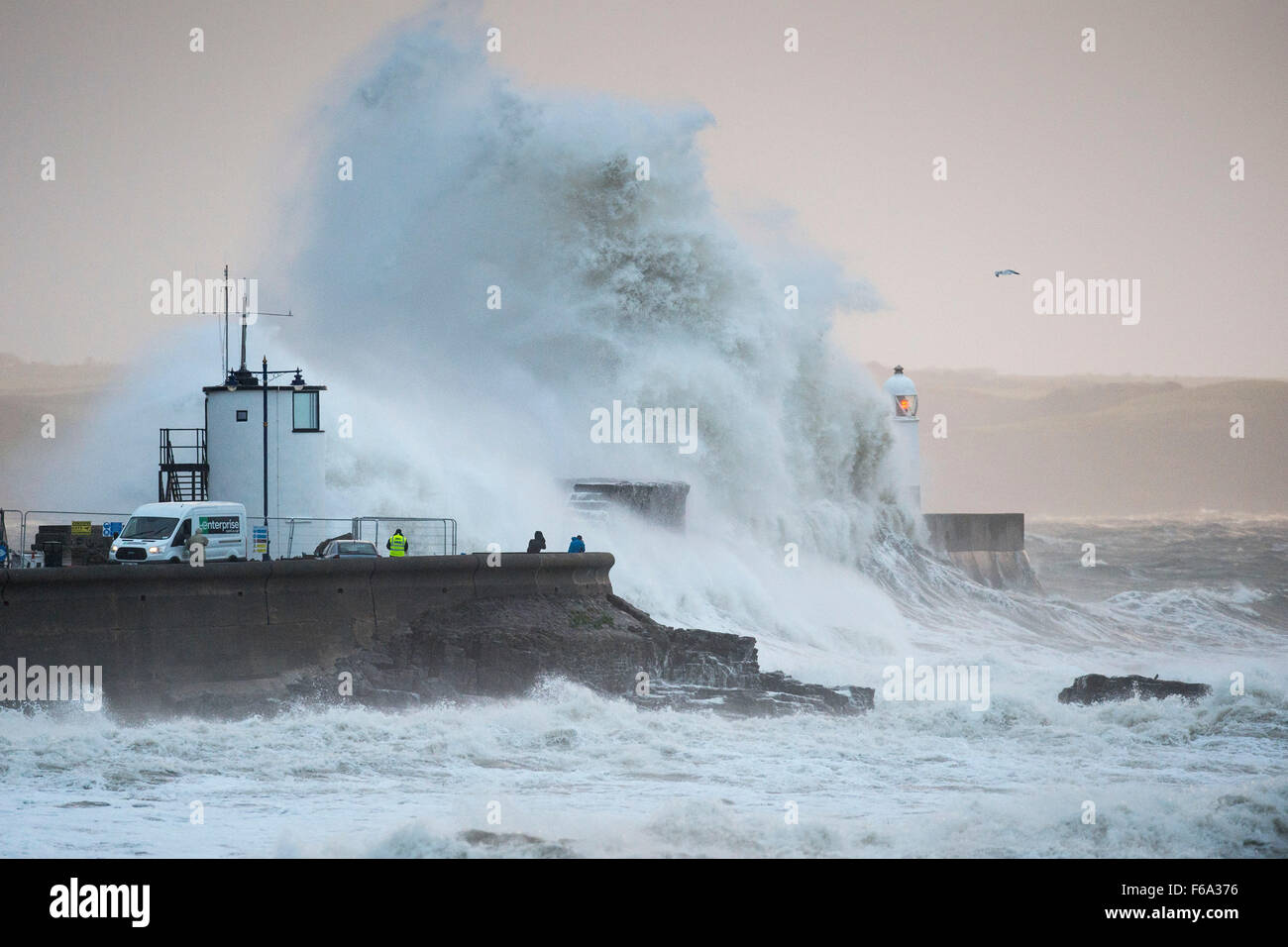 Venti forti causare enormi onde infrangersi oltre il faro di Porthcawl lungomare, nel Galles del Sud, come tempesta Barney arriva. Foto Stock