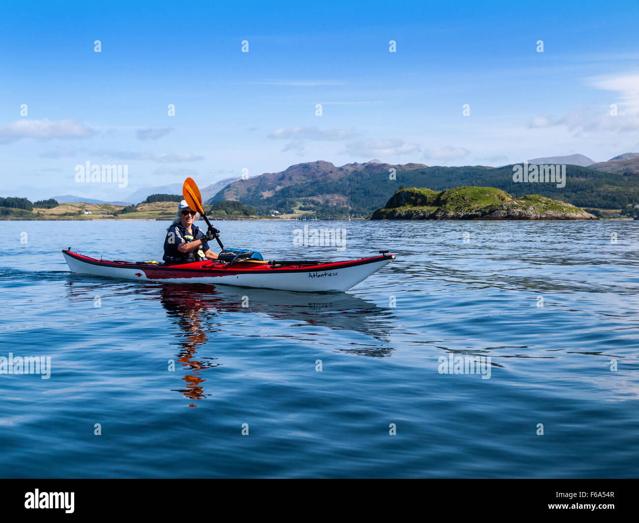 Donna in pensione il kayak da mare intorno all'Isola Shuna sul Loch Linnhe, Scozia occidentale Foto Stock