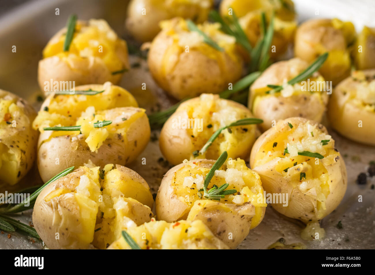 Il rosmarino patate al forno con aglio e sale marino sul vassoio da forno, vicino. Il lato cotto piatto per Natale la tabella Foto Stock