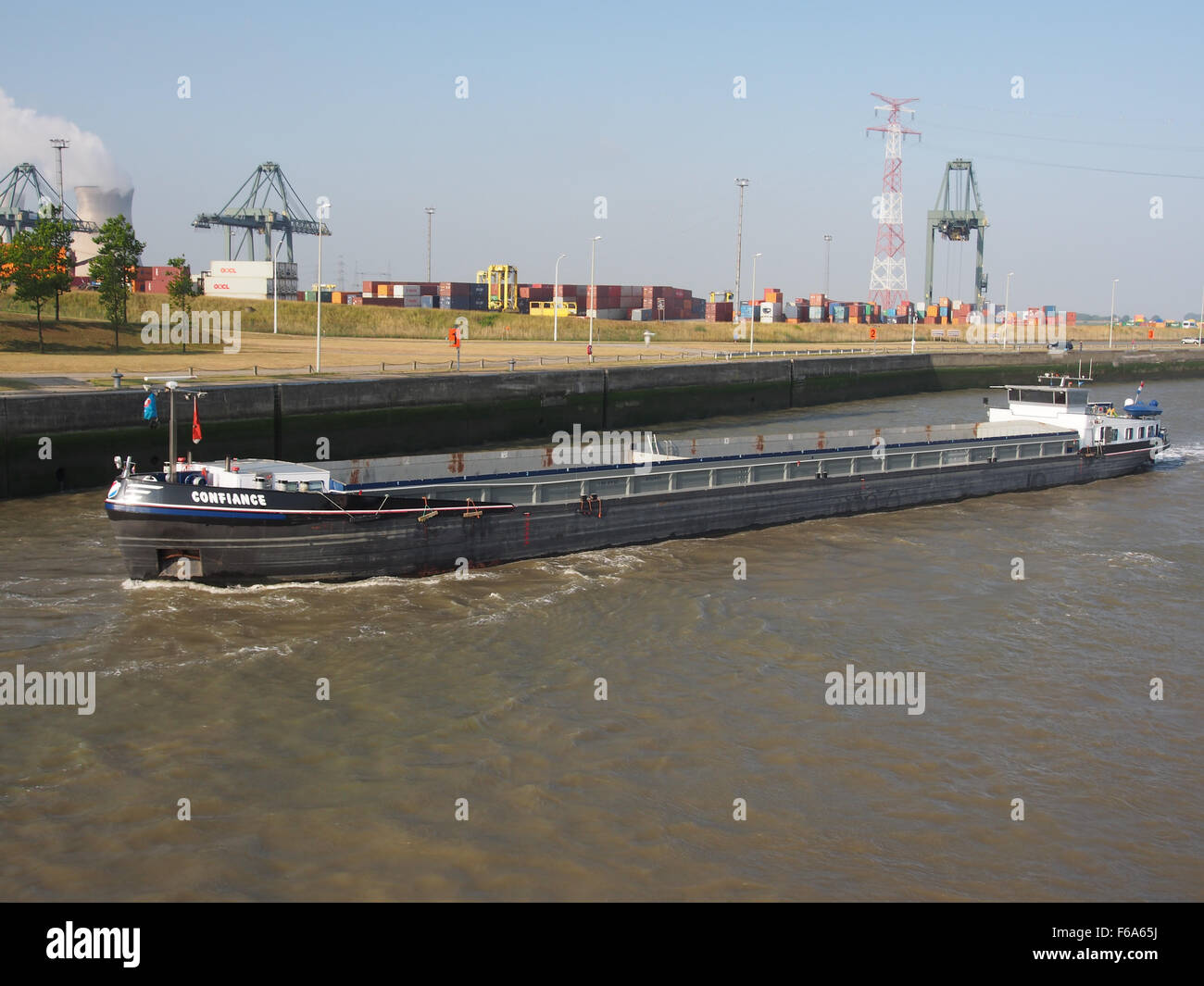 La Confiance, una nave portacontainer registrata come ENI 02321403, si vede navigare nel porto di Anversa Berendrechtsluis. La fotografia illustra la logistica marittima vitale di questo grande porto europeo. Foto Stock