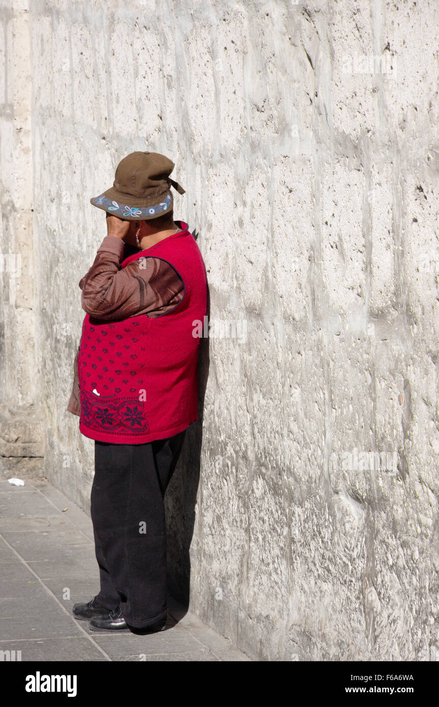 Donna Peruviana vicino a un muro grigio Foto Stock
