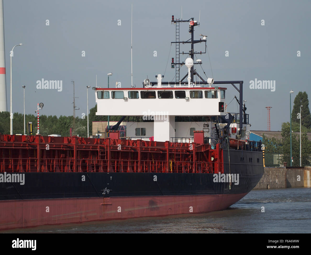 La FRI WAVE, IMO 8915627, è una nave portacontainer e petroliera con segnale di chiamata PJPA, osservata al porto di Zandvlietsluis. Trasporta vari beni tra cui merci generiche, container, carbone e gas. Questa immagine evidenzia la portata e la natura industriale del porto con gru e strutture di stoccaggio per le merci in transito. Foto Stock