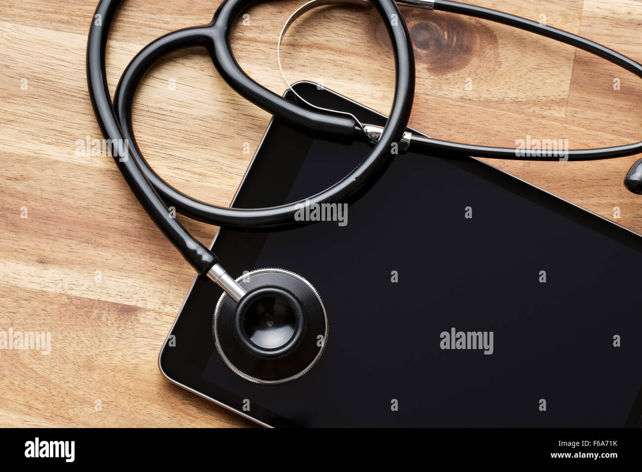 Lo stetoscopio e computer tablet sul tavolo di legno Foto Stock