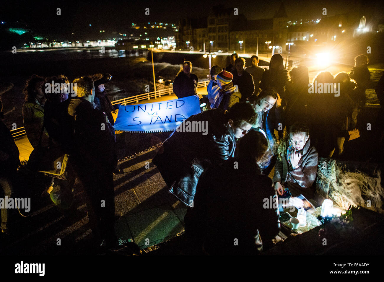 Aberystwyth, Wales, Regno Unito. 15 Nov, 2015. Un gruppo di Aberystwyth studenti universitari tenere un emotivo candela accesa veglia sui gradini della città iconici War Memorial, nella memoria di tutti coloro che furono uccisi a Parigi e gli attacchi terroristici del 13 novembre 2015 Photo credit: Keith Morris / Alamy Live News Foto Stock