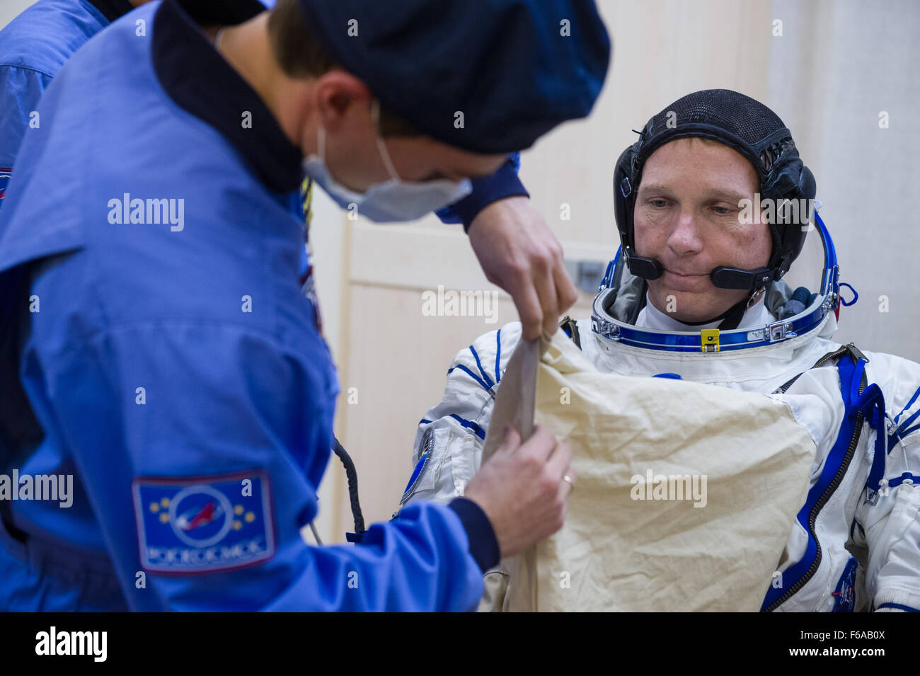 Expedition 42 Tecnico di volo Terry Virts della NASA è aiutato nel suo russo Sokol abito come lui e il compagno crewmates, Tecnico di volo Samantha Cristoforetti dell'Agenzia spaziale europea (ESA), e comandante Soyuz Anton Shkaplerov di l'agenzia Spaziale Federale Russa Roscosmos (), per preparare il loro lancio Soyuz verso la Stazione Spaziale Internazionale, domenica di novembre 23, 2014, presso il cosmodromo di Baikonur di Baikonur in Kazakhstan. Lancio del razzo Soyuz è prevista per le prime ore del 9 novembre 24 e porterà Virts, Cristoforetti e Shkaplerov in orbita per iniziare il loro cinque e mezzo mese missio Foto Stock