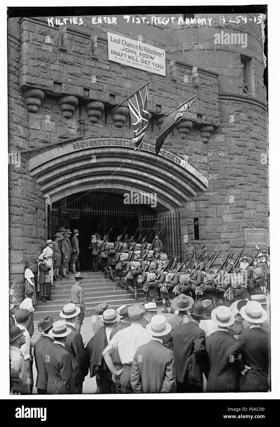 Una fotografia storica dei Kilties, una banda militare in stile scozzese, che entra nell'71st Regiment Armory. L'immagine cattura la formazione del gruppo, vestito con i tradizionali kilt, mentre si preparano per uno spettacolo o una cerimonia. Foto Stock