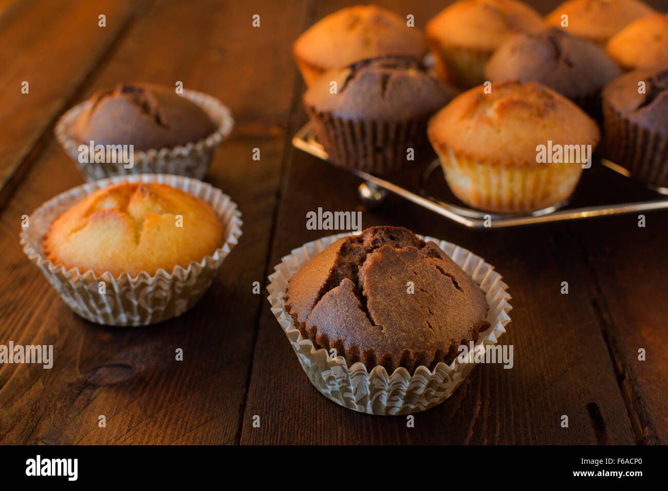 Vaniglia e cioccolato muffin al buio su un sfondo di legno, fuoco selettivo Foto Stock