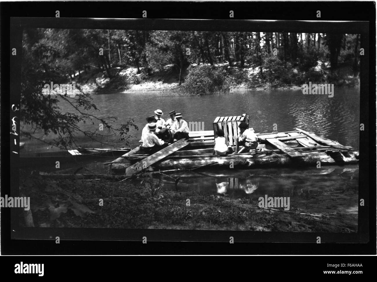Questa fotografia cattura una cerimonia di battesimo che si svolge su una vecchia riva del fiume. L'immagine mostra individui riuniti per il rito religioso, una tradizione comune in molte comunità lungo i fiumi all'inizio del XX secolo. Foto Stock