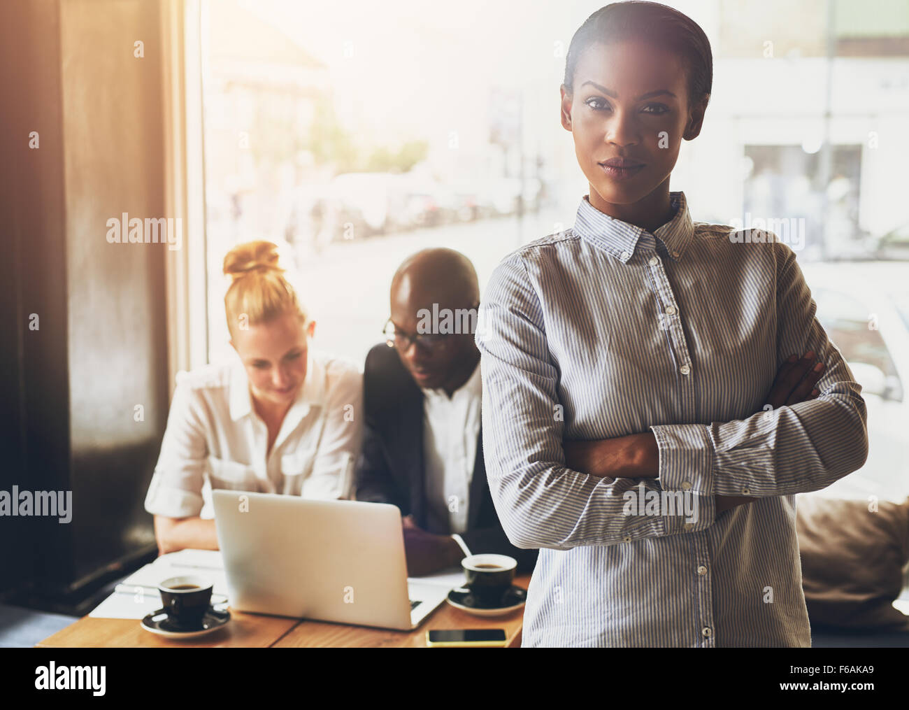 Fiducioso business nero donna in piedi di fronte ai colleghi Foto Stock