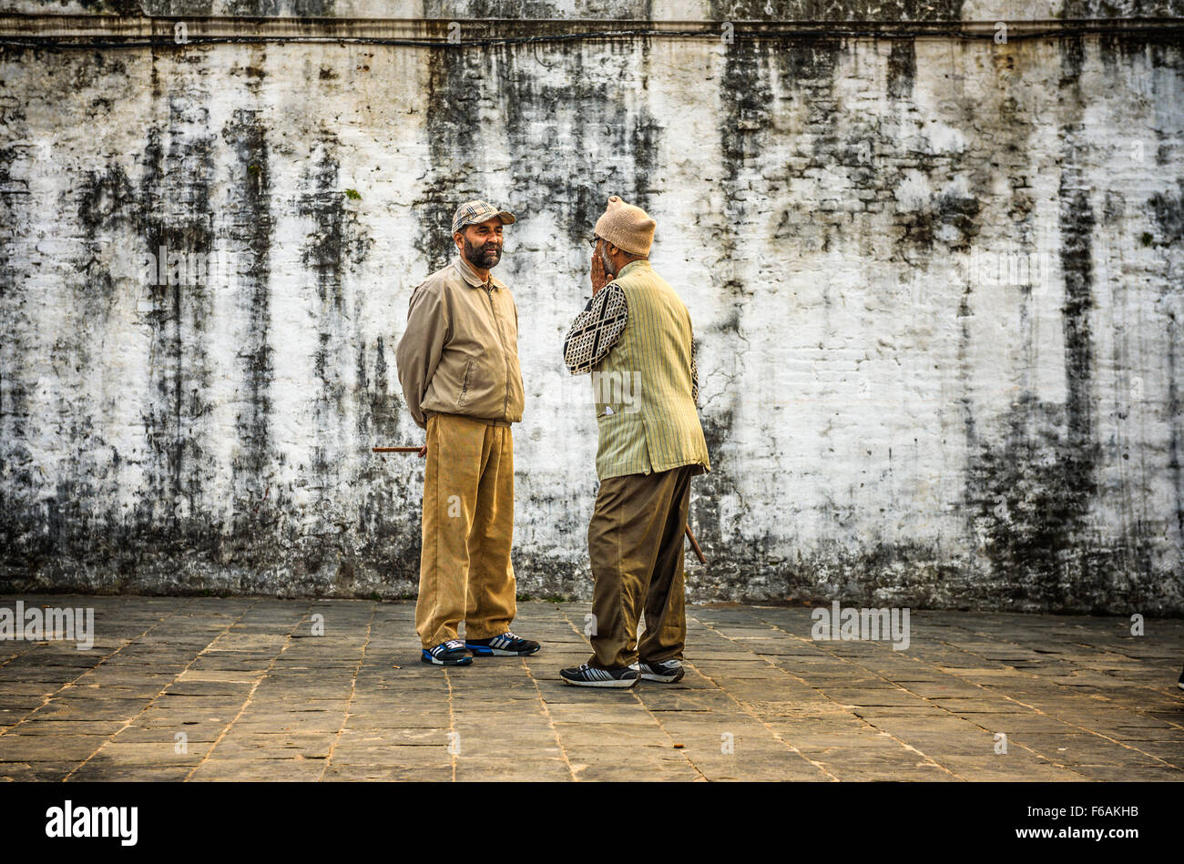 Due uomini di età discutere in strada al tempio di Pashupatinath complessa Foto Stock