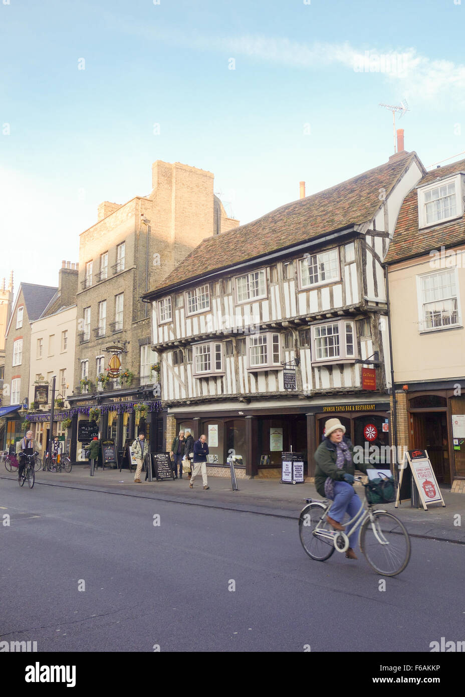 Cambridge Street scene - donna matura escursioni in bicicletta con lo shopping lungo lo storico ponte Street a nord del centro di Cambridge, Regno Unito Foto Stock