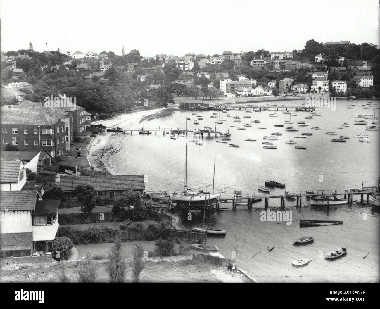 Una storica fotografia in bianco e nero che cattura una vista di Double Bay, nuovo Galles del Sud, con Messenger's Boatshed in primo piano. L'immagine mostra il lungomare e la bellezza costiera della regione. Foto Stock