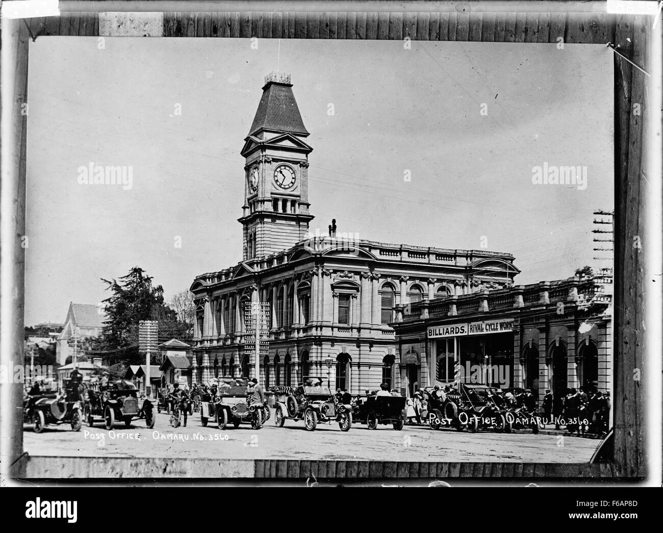 Un'immagine storica di Oamaru, con l'iconico edificio dell'ufficio postale e i veicoli a motore. La fotografia cattura il paesaggio urbano dei primi anni del XX secolo, illustrando la crescita di Oamaru durante questo periodo. Foto Stock