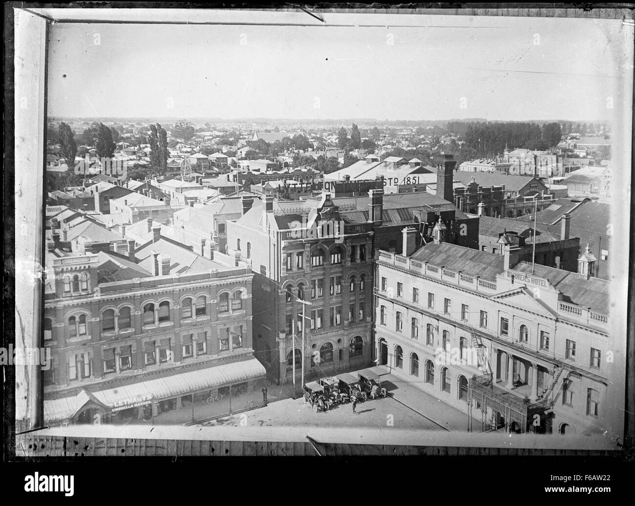 Questa fotografia storica cattura il Warner's Hotel e l'edificio della Lyttelton Times Company Ltd in Cathedral Square, Christchurch. La foto mette in evidenza lo stile architettonico e il layout di questo importante monumento di Christchurch. Foto Stock