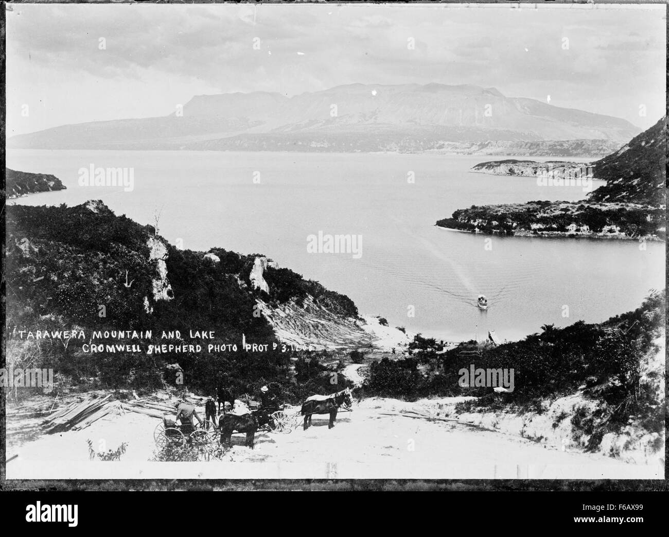 Questa fotografia cattura un traghetto che si avvicina al molo sul lago Tarawera, nuova Zelanda. L'immagine illustra l'ambiente tranquillo del lago, con il traghetto che funge da collegamento principale per la regione. Foto Stock