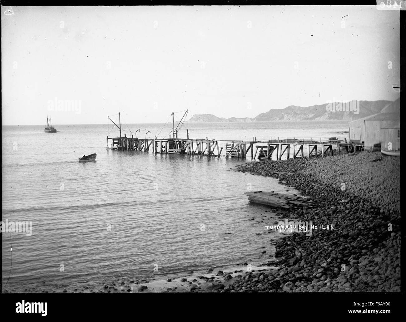 Il molo di te Ariuru, situato all'estremità settentrionale della baia di Tokomaru in nuova Zelanda, funge da struttura marittima locale chiave per l'accesso all'acqua. La baia è conosciuta per le sue acque tranquille e gli splendidi paesaggi circostanti. Foto Stock