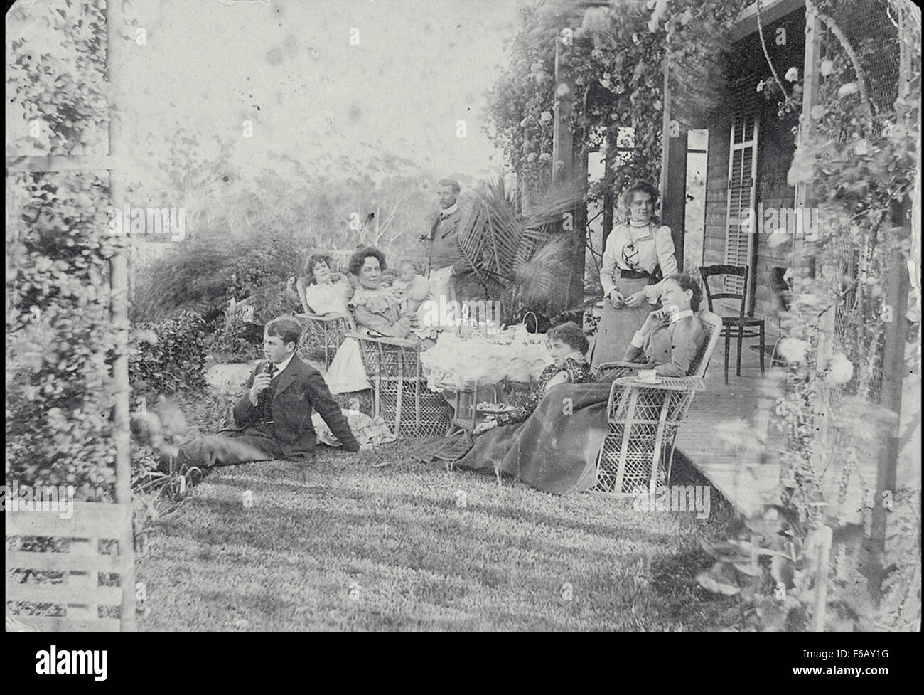 Questa fotografia cattura un tranquillo tè pomeridiano in giardino organizzato da Robert Morse e Frances A. Withycombe a Hurstville, Sydney. La scena evoca l'atmosfera sociale degli incontri dei primi anni del XX secolo, mostrando l'eleganza e lo stile del tempo. L'immagine funge da documento storico della vita sociale e della cultura domestica all'inizio di Sydney. Foto Stock