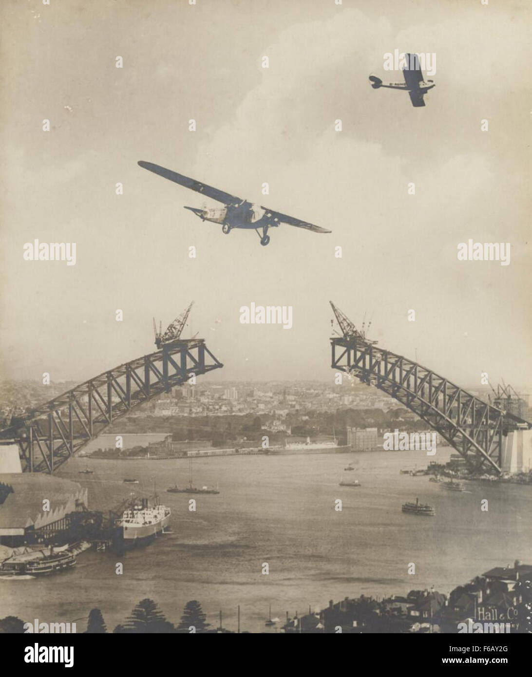 Il Southern Sun, un importante aereo di linea del suo tempo, sorvola il Sydney Harbour Bridge nel 1931. Questa fotografia storica cattura un momento di successi nell'aviazione e sviluppo urbano a Sydney. Foto Stock