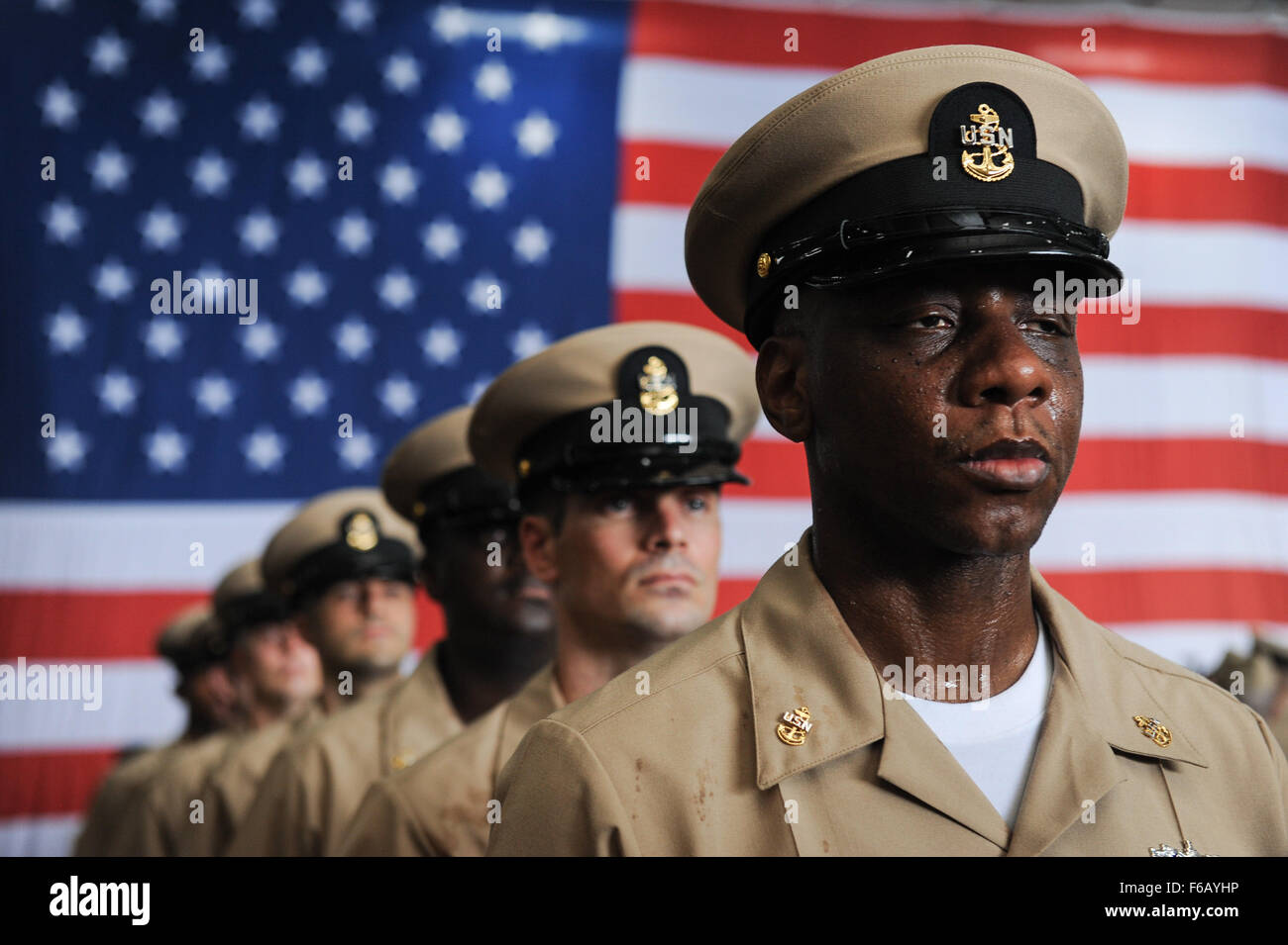 150915-N-GR120-201 GOLFO ARABICO (sett. 15, 2015) - Nuovo capo danno Controlman Keith Frizell sorge all attenzione dopo essendo imperniata al chief petty officer durante un chief pinning cerimonia a bordo della portaerei USS Theodore Roosevelt CVN (71). Quaranta-quattro capi sono state riposte dal compagno di capi in una tradizionale cerimonia in un hangar bay a bordo Theodore Roosevelt. Theodore Roosevelt è distribuito negli Stati Uniti Quinta Flotta area di operazioni di supporto inerente operazione di risolvere, colpire le operazioni in Iraq e Siria come diretto, le operazioni di sicurezza marittima e di teatro la cooperazione in materia di sicurezza gli sforzi in t Foto Stock