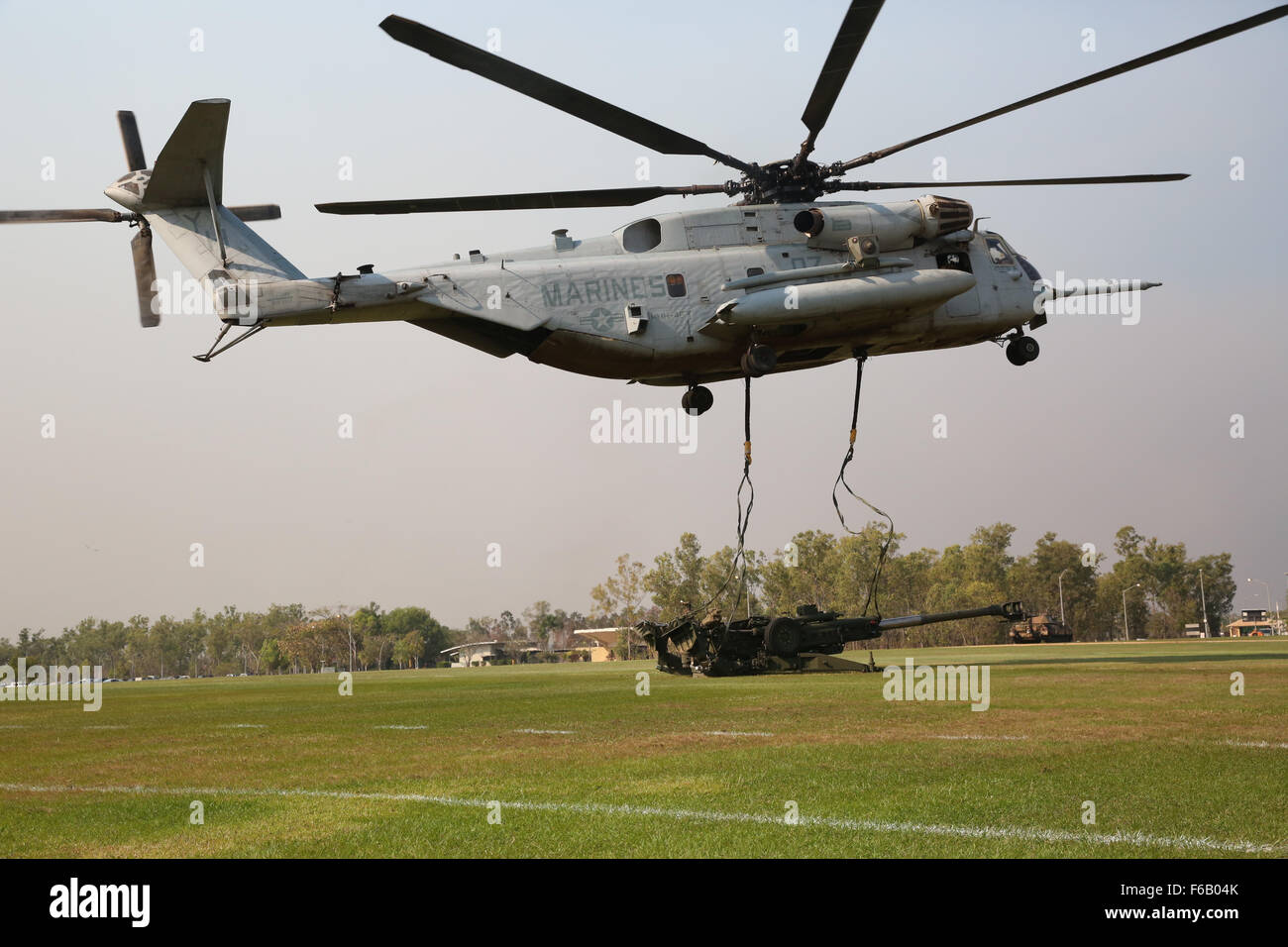 Un U.S. Marine Corps CH-53E Super Stallion elicottero con Marine elicottero pesante Squadron 463, Marine forza rotazionale - Darwin, rilascia le cinghie dopo un ascensore esterno di un M777A2 leggero 155 mm obice Agosto 5, al Robertson caserma, Palmerston, Northern Territory. Il Marine i piloti e gli equipaggi degli aeromobili, insieme con i soldati con 8th/ XII Reggimento Royal Australian artiglieria, 1° Brigata, Esercito Australiano, Australian Defence Force, pianificate e condotte di sollevamento esterni dei obice e familiarizzarsi entrambe le unità con ciascuno degli altri procedimenti di formazione per migliorare l'interoperabilità. Il MRF-D s Foto Stock