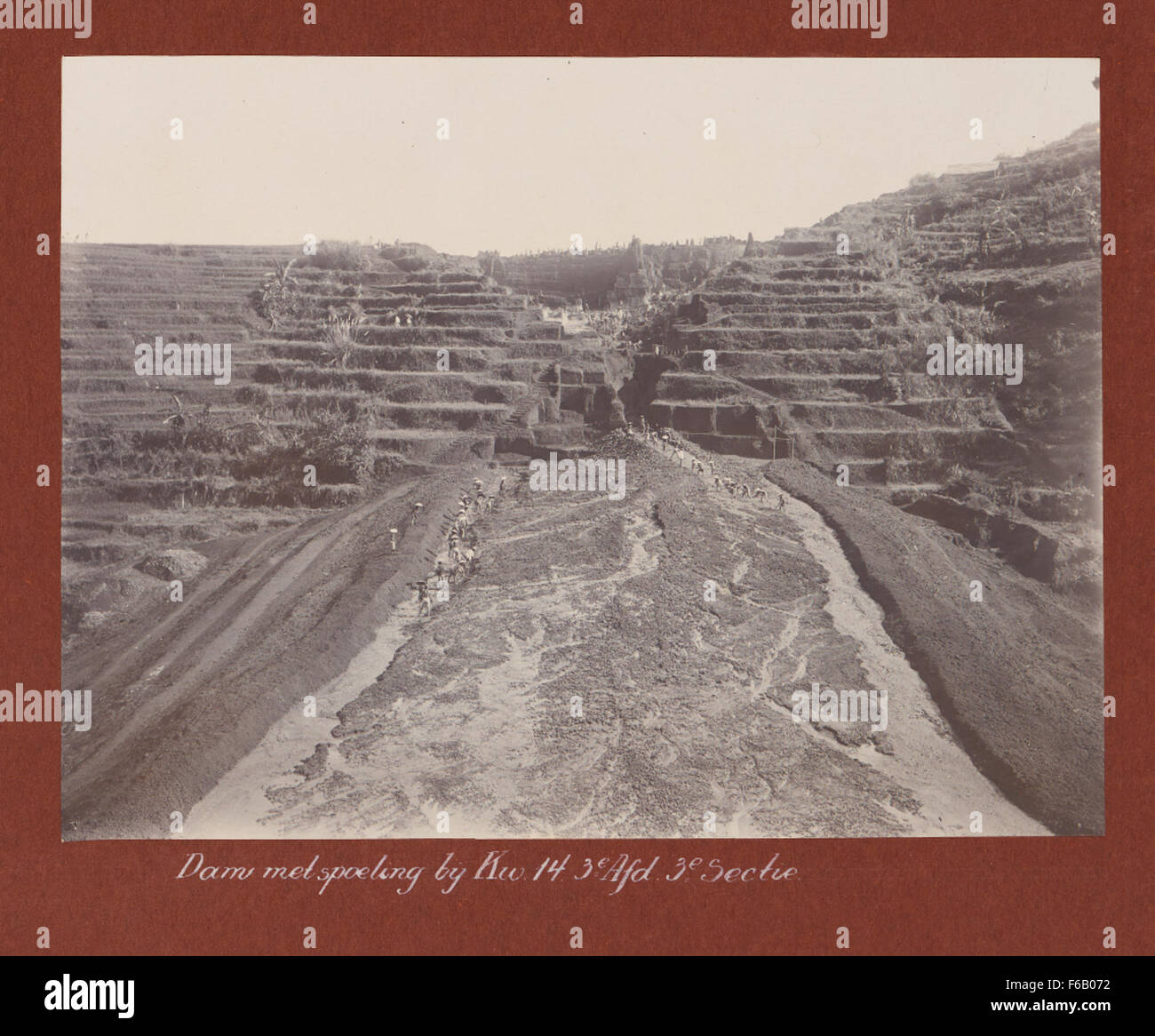 Questa immagine storica cattura la costruzione di una diga vicino a kW. 14, parte della terza sezione del progetto delle Ferrovie dello Stato. Raffigura lavoratori che costruiscono infrastrutture vitali per l'espansione delle ferrovie nei Paesi Bassi durante la fine del XIX secolo. Foto Stock
