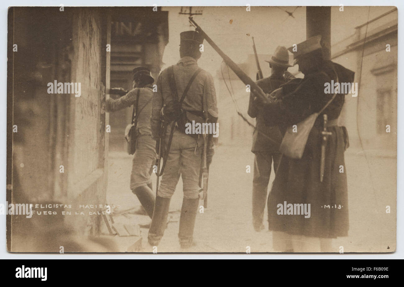 Questa cartolina fotografica reale (RPPC) della Rivoluzione messicana cattura una scena a vera Cruz con Felicistas che accende un incendio per strada. L'immagine ritrae la tensione del periodo, con soldati e pistole sullo sfondo, evidenziando l'atmosfera rivoluzionaria e la presenza militare in Messico durante questo periodo turbolento. Foto Stock