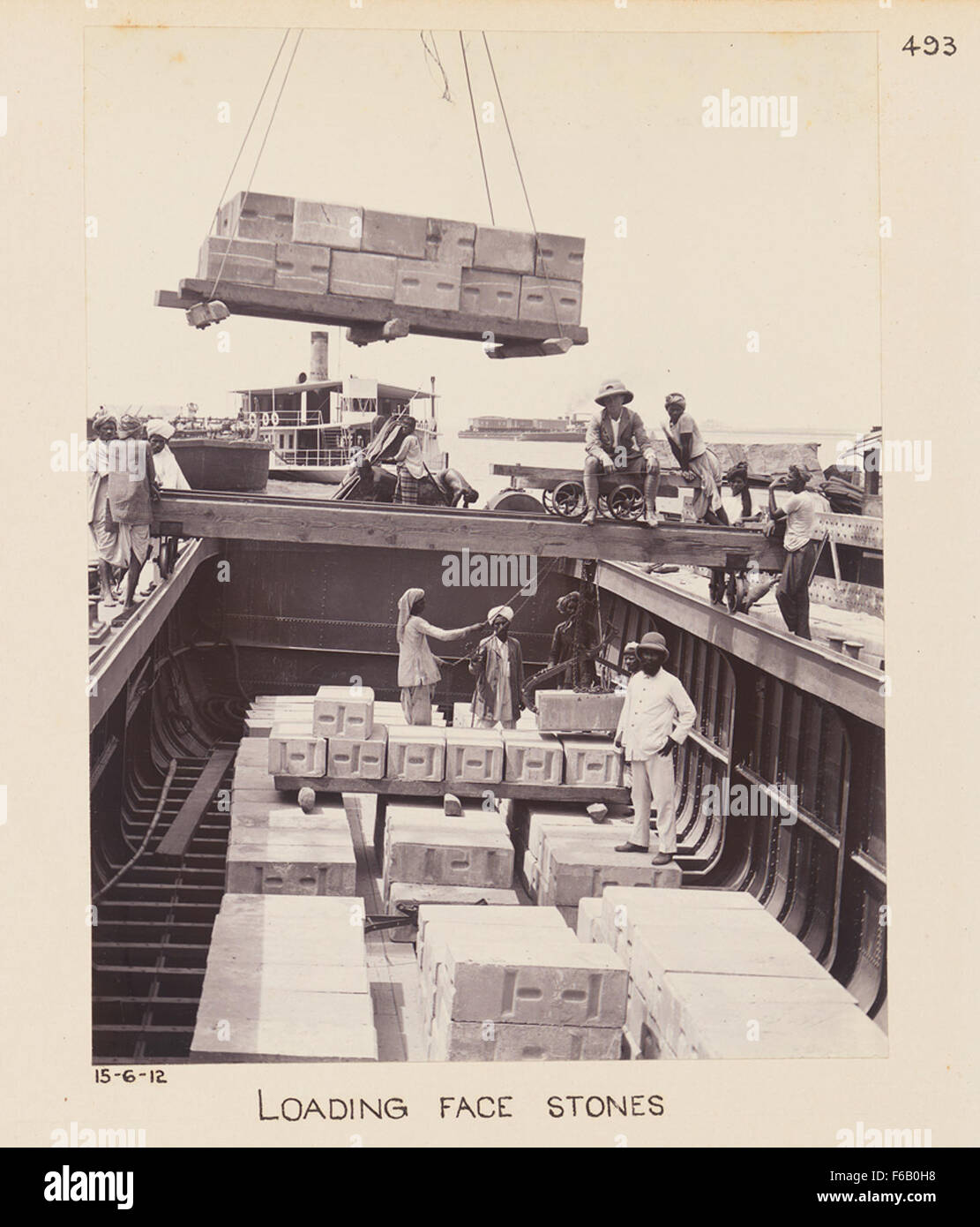 L'immagine raffigura la costruzione di un ponte ferroviario, probabilmente all'inizio del XX secolo. Mostra i lavoratori che caricano pietre frontali, materiali essenziali utilizzati per la fondazione di ponti ferroviari, che hanno svolto un ruolo fondamentale nell'espansione delle ferrovie e delle infrastrutture. Foto Stock